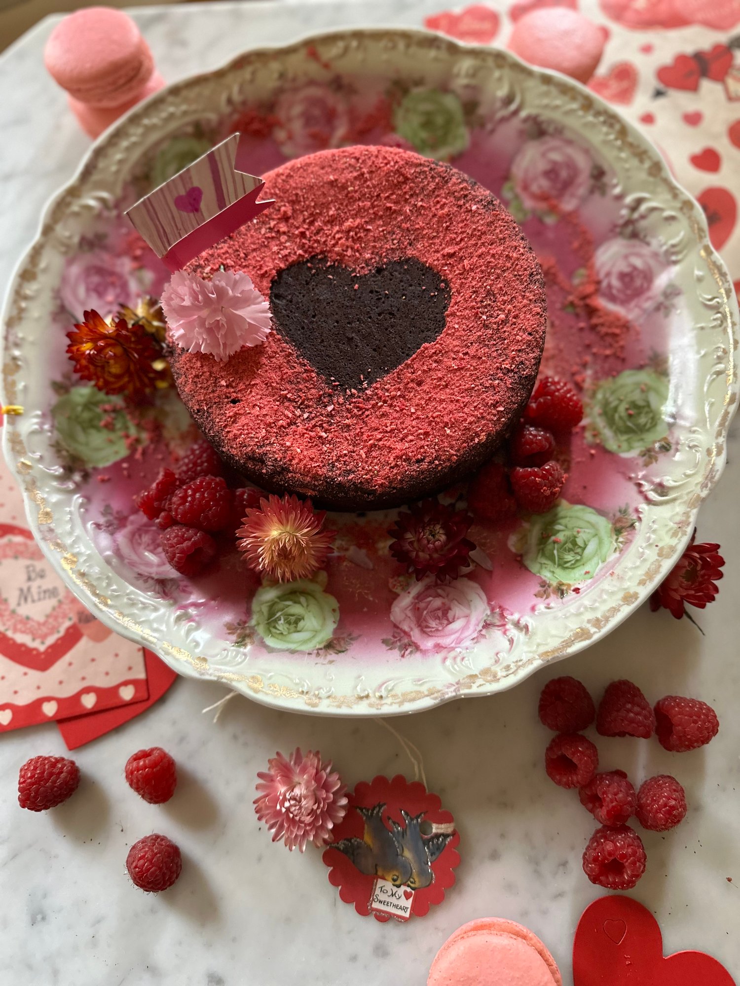 Decorated cake with heart, raspberries and flowers